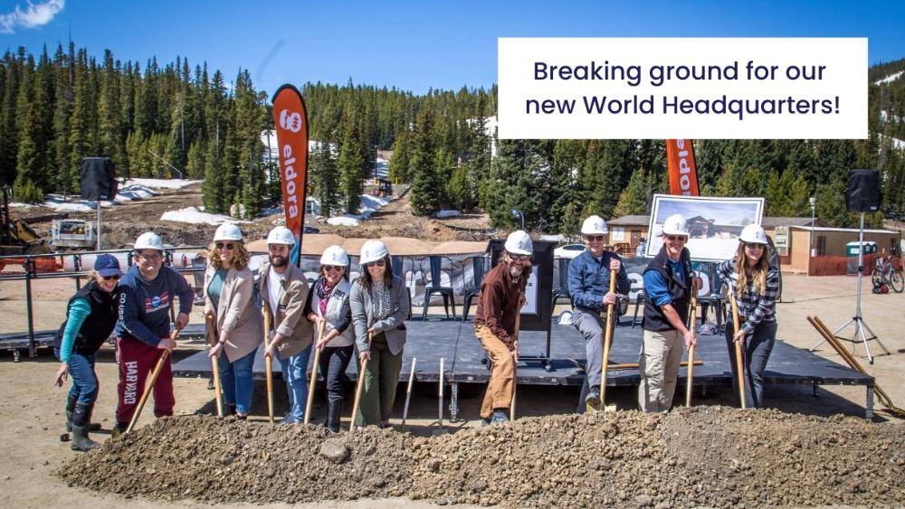 Ignite Adaptive Sports team members wearing hard hats and using shoves outdoors with text: Breaking ground for our new World Headquarters!