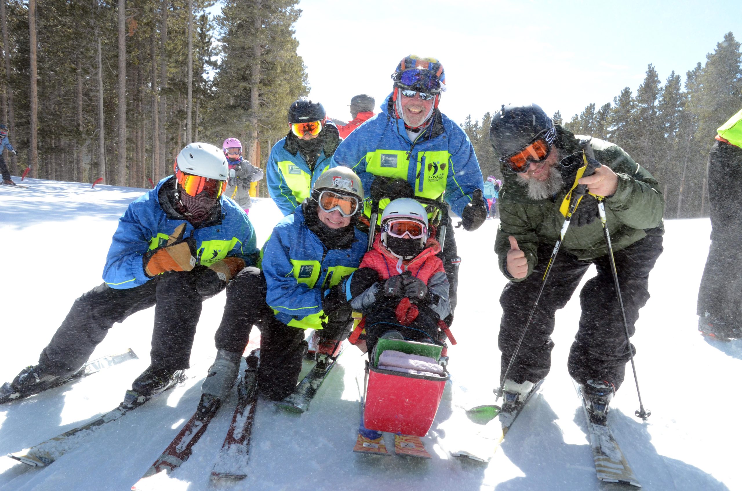 A group of volunteers and athletes smiling on a sunny Eldora day.