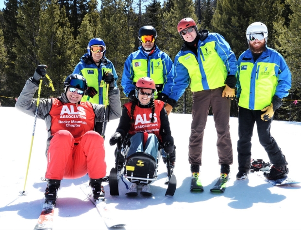 two Ignite Athletes from ALS Association Colorado posing with Ignite Volunteer Instructors on top of a ski run