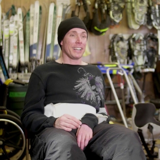 Eric Raley sitting in Ignite Adaptive Sports' equipment room for an interview