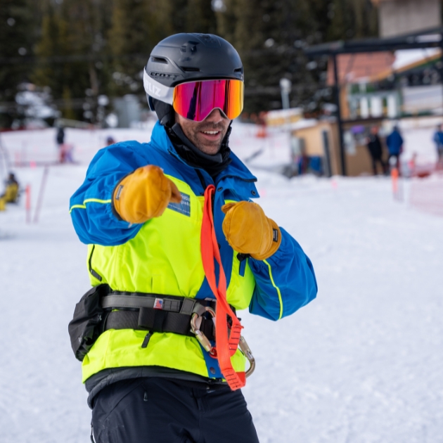 Ignite Volunteer Instructor smiling for the camera at the bottom of a run