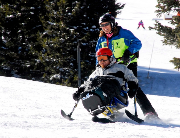 Ignite Athlete going down the mountain with an Ignite Volunteer Instructor on a sit ski