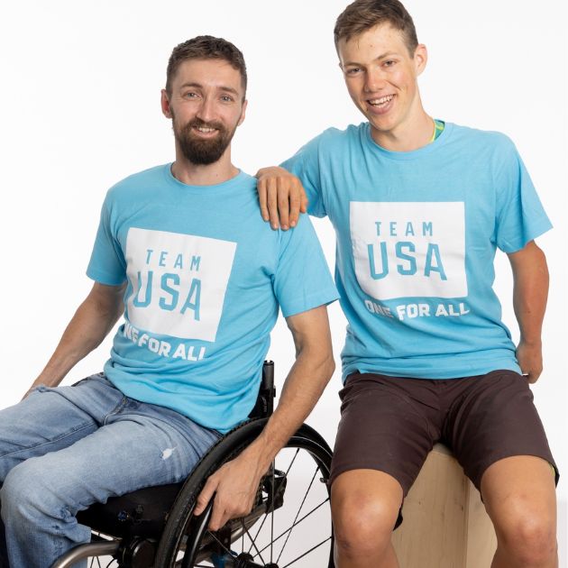 Two men in matching “Team USA” shirts, one in a wheelchair.
