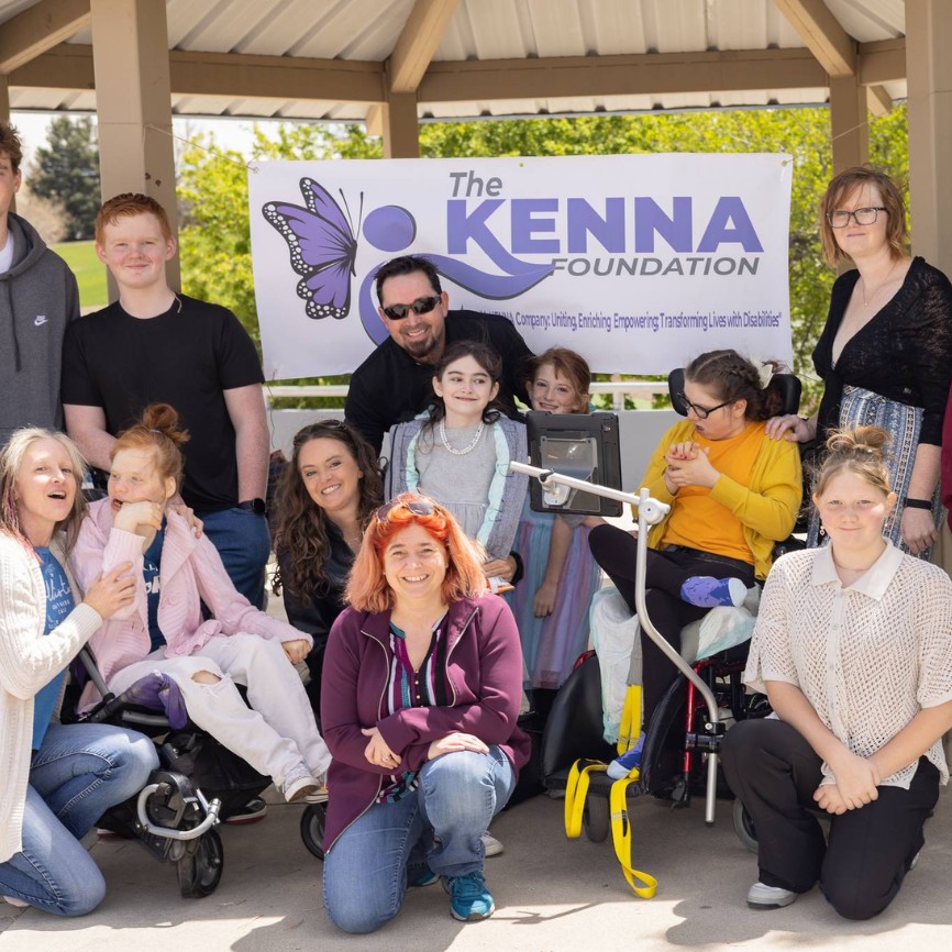 A group of smiling adults and children, including individuals with developmental disabilities